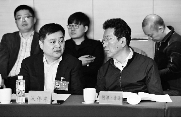今年兩會期間,，阿沛·晉源（右）在界別小組討論會上,。    本報記者  齊波  攝