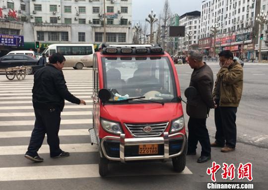營(yíng)山城區(qū)電動(dòng)四輪車司機(jī)正在討論車輛的車況,?！⒅铱?攝