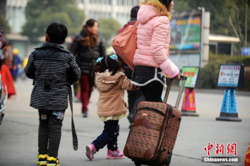 資料圖：2015年2月5日,，2015年春運第二天,，江蘇揚州市汽車西站迎來客流高峰,，圖為家長帶著孩子在江蘇揚州市汽車西站候車,。 孟德龍 攝