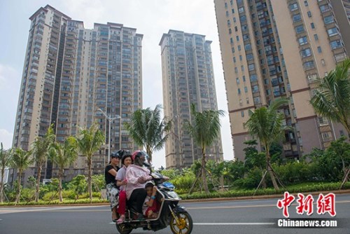 資料圖：市民在?？谑袇^(qū)某地產(chǎn)項目前路過,。 <a target='_blank' href='http://www.chinanews.com/'>中新社</a>記者 駱云飛 攝