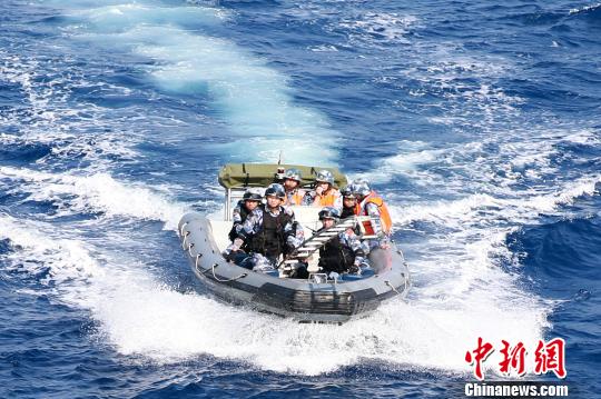 特戰(zhàn)隊(duì)員乘小艇攜帶掛梯出擊，演練解救被劫船舶,?！×纸?攝