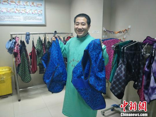 黨懿展示心內(nèi)科醫(yī)生做心臟介入手術(shù)時(shí)需要穿的鉛衣，全套共重36斤,?！〈逎?攝