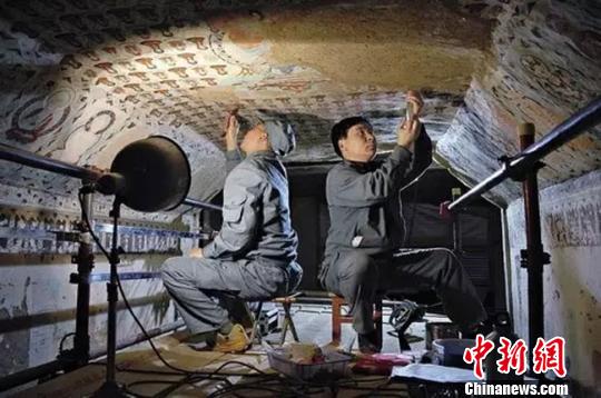圖為敦煌守護(hù)者在修復(fù)壁畫(huà),。敦煌研究院供圖 攝