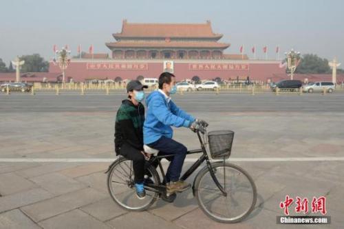 資料圖：一對(duì)青年佩戴口罩騎車經(jīng)過北京天安門廣場(chǎng),。 <a target='_blank' href='http://www.chinanews.com/'>中新社</a>記者 崔楠 攝