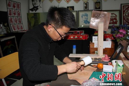 圖為魏康龍正在制作皮雕,?！顤|東 攝