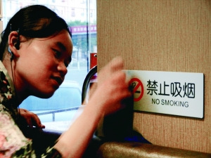 昨日，在北京西城某餐廳店員正在擦拭禁止吸煙標(biāo)志,。北京晨報記者 姜浩波/攝