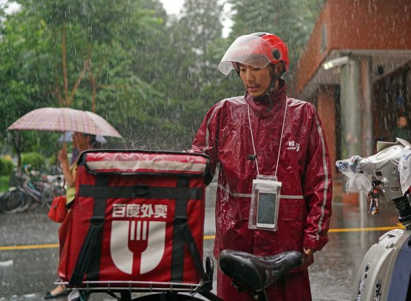 外賣送貨員在暴雨中堅(jiān)持工作。新華社記者陳誠(chéng)攝