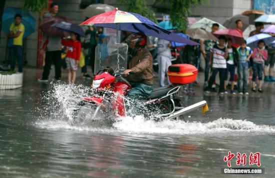 6月12日,，貴陽市民騎摩托車在積水路段行駛。<a target='_blank' href='http://www.chinanews.com/'>中新社</a>記者 賀俊怡 攝