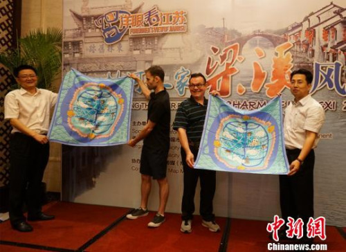 圖為無(wú)錫方面贈(zèng)送手繪梁溪地圖絲巾給外籍人士代表?！O權(quán) 攝