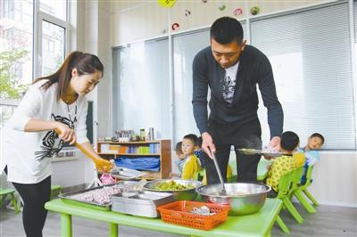 逄秋香,、陳亮夫妻倆為幼兒園孩子盛午飯,。