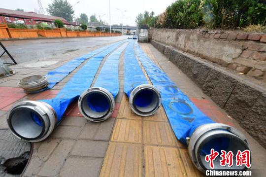 北京地區(qū)于21日午后陸續(xù)迎來降水,。北京市通州區(qū)組建了19支應(yīng)急搶險(xiǎn)隊(duì)伍，8582名應(yīng)急搶險(xiǎn)人員隨時(shí)待命,。圖為通州區(qū)相關(guān)部門進(jìn)行排水,。　常鳴 攝