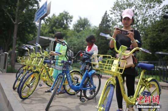 資料圖 6月8日,，民眾在北京街頭掃碼租用一款“土豪金”色的共享單車。 <a target='_blank' href='http://www.chinanews.com/'>中新社</a>記者 楊可佳 攝