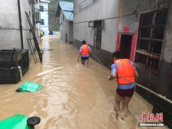 圖為浙江省麗水市遂昌縣民警在積水中準(zhǔn)備營(yíng)救居民,。