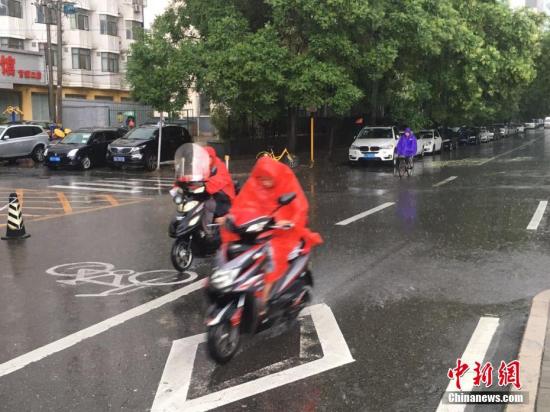 6月23日清晨,，北京降雨持續(xù)，并出現(xiàn)了短時大雨,。據(jù)北京市氣象局官方微博消息,，北京市氣象臺今日6時發(fā)布：今天白天小到中雨并伴有雷電，傍晚局地伴有短時大風或冰雹,，北轉東風2,、3級，最高氣溫24℃,；夜間有雷陣雨,，東轉北風2、3級,，最低氣溫19℃,。圖為北京阜成路，市民雨中騎行,。 <a target='_blank' href='http://www.chinanews.com/' >中新網</a>記者 富宇 攝