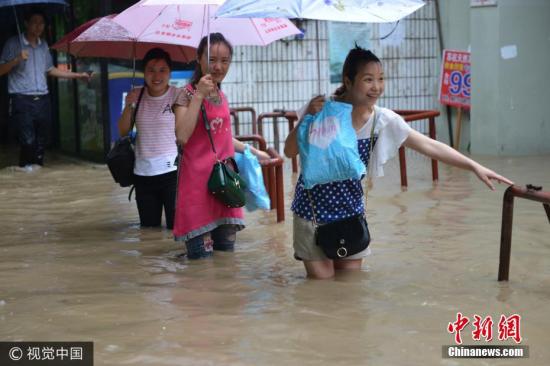 圖為南京市雨花臺(tái)區(qū),，市民在水中艱難出行,。圖片來源：視覺中國