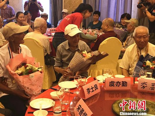 志愿者為抗戰(zhàn)老兵獻上鮮花,?！铑伌?攝