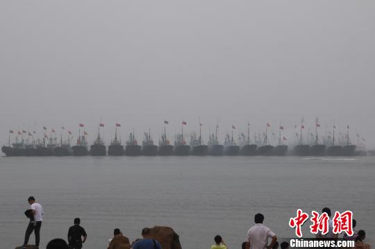 當(dāng)?shù)貪O民駕駛著掛滿紅綢的漁船開啟祭海巡游，駛向主祭壇所在地——海上碑龍王廟,?！埼髦?攝