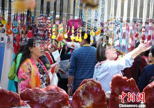 圖為華教代表在觀看民族特色工藝品?！」⒌さ?攝