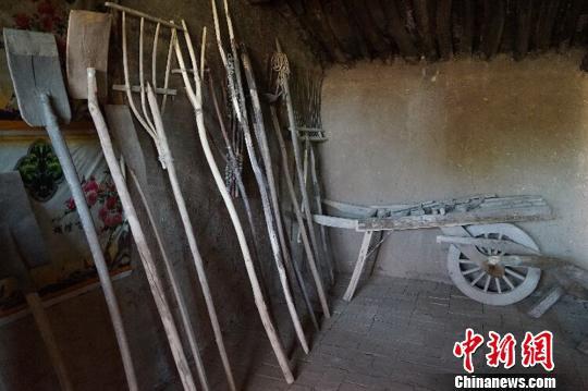 何世前的農(nóng)家小屋里，整齊地陳列著年代不種的農(nóng)具和生活用品,?！￡愃?攝