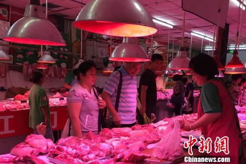 北京陶然亭公園附近一家農(nóng)貿(mào)市場(chǎng)內(nèi),，正有消費(fèi)者在挑選五花肉,。<a target='_blank' href='http://www.chinanews.com/' >中新網(wǎng)</a> 種卿 攝