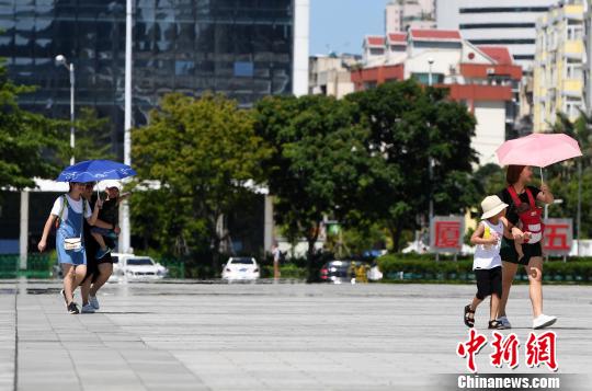 7月13日,，廈門(mén)市民行走在熱浪滾滾的路面上?！埍?攝