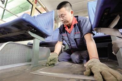 7月16日，五里店公交車修理廠,，李元兵師傅在高溫天里檢修車輛。本報記者 胡杰 攝