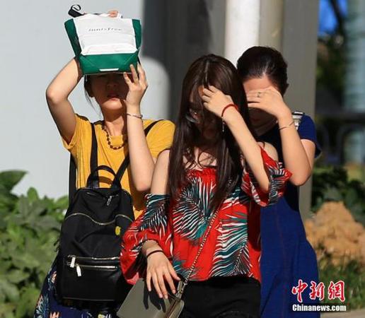 7月20日,，武漢高溫持續(xù)，出行的市民用手和隨身物品遮擋陽光,。<a target='_blank' href='http://www.chinanews.com/'>中新社</a>記者 張暢 攝