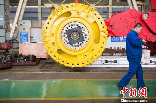 山西太重工人從采煤機(jī)前經(jīng)過,。　張?jiān)?攝