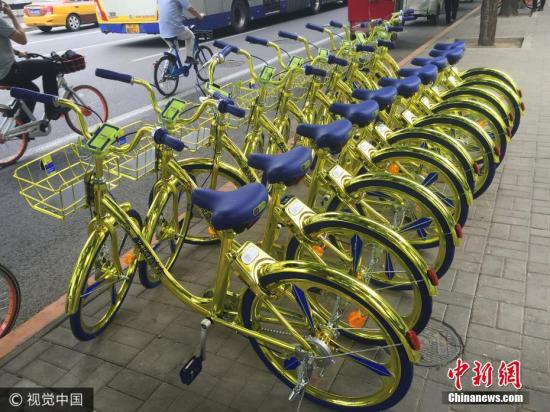 資料圖：6月8日，北京,，金色共享單車現(xiàn)身朝陽區(qū)望京街頭,。該共享單車配備充電模塊，可以給手機充電,。 圖片來源：視覺中國