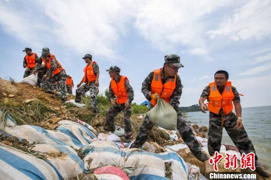 資料圖片,，民兵應(yīng)急分隊(duì)冒著酷熱進(jìn)行堤壩加固?！「到ū?攝