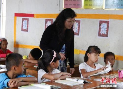 9月22日,，在偏遠(yuǎn)山區(qū)的廣西柳江縣穿山鎮(zhèn)六廟小學(xué),，幾間瓦房教室、宿舍,，操場(chǎng)上3張乒乓球臺(tái)就是學(xué)生和老師的一切,。48歲的韋鳳玲在給學(xué)生們上課，“下雨時(shí),，人在上課雨從頭頂落”,，韋鳳玲這樣形容學(xué)校環(huán)境。2014年從老撾完成兩年支教任務(wù)的柳江縣第二中學(xué)教師韋鳳玲,，又到該縣土博鎮(zhèn),、穿山鎮(zhèn)村級(jí)小學(xué)支教，被稱為支教“專業(yè)戶”,。朱柳融 攝