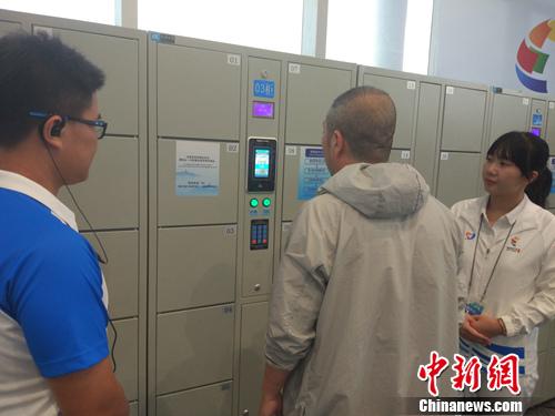 志愿者幫助記者使用電子儲物柜,。