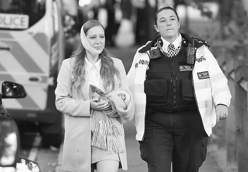英國安全人員陪同傷者離開爆炸現(xiàn)場,。