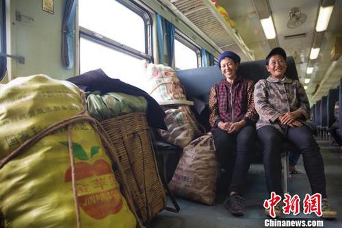 資料圖：穿行大涼山的“扶貧列車”,。在普雄開(kāi)往攀枝花的5633次列車上，兩名到喜德販賣土豆的彝族婦女正守護(hù)著自己的貨品,?！↓忀妗z