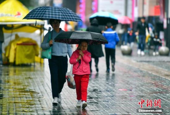 資料圖：9月24日，新疆烏魯木齊市降下秋雨,，外出民眾打著雨傘快步前行,。 <a target='_blank' href='http://www.chinanews.com/'>中新社</a>記者 劉新 攝