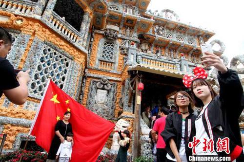 圖為游客爭(zhēng)相在國(guó)旗前合影,?！埖勒?攝