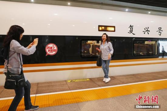資料圖：旅客與“復(fù)興號(hào)”列車合影留念,。殷立勤 攝
