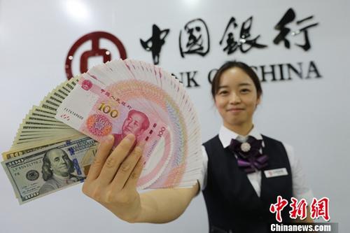 8月15日,，山西太原，銀行工作人員展示人民幣,、美元,。<a target='_blank' href='http://www.chinanews.com/'>中新社</a>記者 張?jiān)?攝