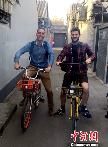 英國(guó)人Chris Georgiou(左)和朋友在北京騎共享單車(chē)逛胡同,。受訪者供圖