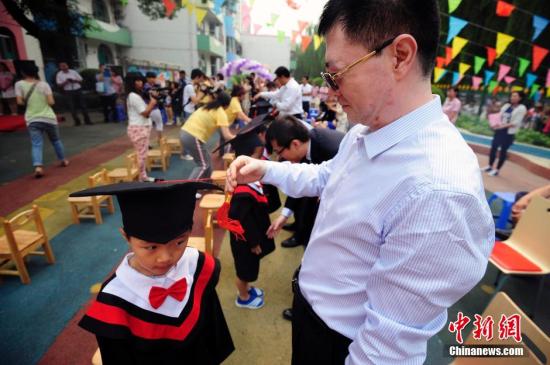 資料圖：山西太原一幼兒園的孩子們穿上學(xué)士服參加畢業(yè)典禮,。<a target='_blank' href='http://www.chinanews.com/'>中新社</a>發(fā) 張?jiān)?攝