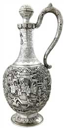醒酒壺   Wine Decanter 晚清 通高：30.5cm,；腹徑：13cm,；重：774g 款識(shí)：大吉     這件銀壺造型獨(dú)特，長頸鼓腹,，通身錘揲有人物故事紋,，頸部更鏨刻有蕉葉紋、葡萄紋,、竹枝紋,，并貼焊“巴為芻夫”四字。整件器物僅有上方一球狀壺塞的壺口,，并無設(shè)計(jì)流口,，都說明這并非盛裝飲品的茶壺，而是一件醒酒壺,。西方人不僅愛喝茶,，同樣也愛美酒，且更多的是飲用葡萄酒,，葡萄酒內(nèi)富含的單寧酸常常會(huì)使酒品嘗的口感變澀,，這也是葡萄酒需要“醒酒”這一程序的由來，而中國銀匠為滿足西方人的飲酒需要,，創(chuàng)作出了銀制的醒酒壺,。有趣的是，醒酒需要讓酒盡可能大面積的與空氣接觸,，使得酒類的單寧酸迅速氧化揮發(fā)，而該壺并無此特點(diǎn),，這也是由于當(dāng)時(shí)的銀匠缺乏對(duì)葡萄酒的相關(guān)知識(shí)而造成的失誤,，只知有“醒酒”這道工序，而不知醒酒的原理，可謂是時(shí)代造就的一個(gè)美麗的誤會(huì),。