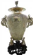 人物故事龍耳瓶   Dragon-shape-handled Vase with Figures and Story Scene Pattern   晚清 帶座通高：57cm；不帶座通高：49cm,；腹徑：27cm,；不帶座重：3276g 款識(shí)：德昌,，HUNGCHONG&CO   銀器實(shí)用性、觀賞性兼具,，一直深受西方人的喜愛，很多時(shí)候都作為禮物和獎(jiǎng)品的不二選擇,。這件人物故事龍耳瓶,，瓶鈕及兩側(cè)的雙耳皆以龍首為造型設(shè)計(jì)，加之器型高大,，整體極具氣勢(shì),。兩側(cè)雙耳是以龍首口中吐出的流水形成下沿，通身布紋為底,，通過錘揲工藝創(chuàng)作出刀馬人物故事圖,，底座被設(shè)計(jì)成三名孩童雙手捧持瓶底，下方配一紫檀底座,，極具藝術(shù)感,。

　　除開整體造型及瓶身上繁復(fù)的紋飾外，最引人著目的當(dāng)屬瓶身中部的方形銘牌,，在中日甲午戰(zhàn)爭(zhēng)中,，數(shù)位德、英官兵曾在北洋艦隊(duì)上協(xié)助作戰(zhàn),，而在銘牌上的德語銘文,，正是向這批德、英軍士們致以最崇高的敬意,，也使得這件器物成為了中日甲午戰(zhàn)爭(zhēng)的歷史見證之一,，更顯珍貴。