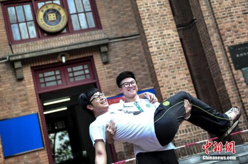 資料圖：一名高考考生抱起同學(xué)在考場前合影留念,。<a target='_blank' href='http://www.chinanews.com/'>中新社</a>記者 陳驥旻 攝