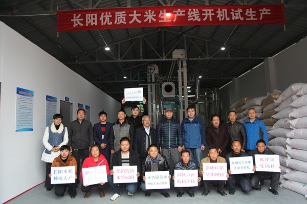 長陽優(yōu)質大米生產線》開機試生產,。長陽土家族自治縣農業(yè)局局長程剛（后排又四）,、副局長董俊波（后排右二）、水稻種植專家李勁松（后排右一）,，長陽縣政協(xié)吳建波（后排右三）等到生產現(xiàn)場參觀指導,。