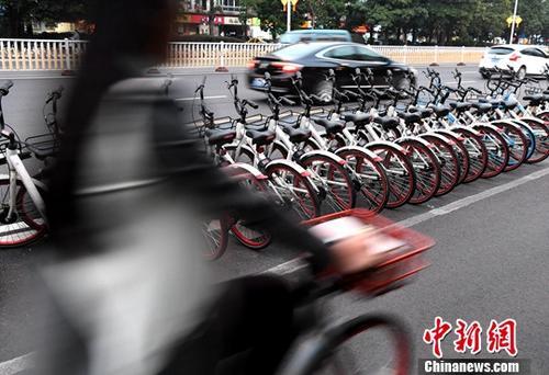 資料圖：路人騎著共享單車經過“車堆”,。<a target='_blank' href='http://www.chinanews.com/'>中新社</a>記者 張斌 攝