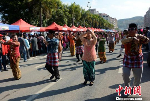 踩街隊伍在美食街上穿行表演，整個活動現(xiàn)場成為歌舞的海洋,。　張金川　攝