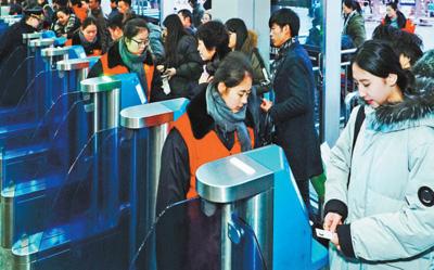 2月1日，旅客正在北京西站通過自助驗票設備“刷臉”進站,。該站今年增加了18臺人臉識別設備,，方便旅客快速進站,。本報記者 賀 勇攝