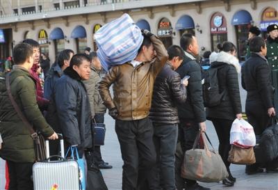 　昨日，北京站,，乘客背著行李準(zhǔn)備進(jìn)站乘車,。本版攝影/新京報記者 王貴彬 朱駿 實習(xí)生 陳婉婷