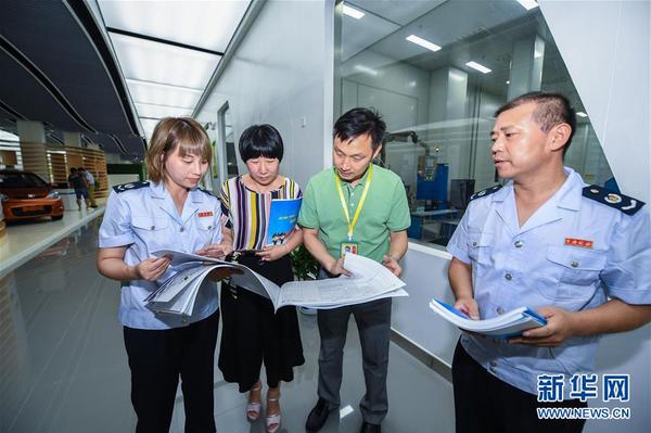 浙江省長興縣地稅局工作人員在新能源企業(yè)超威集團給相應(yīng)部門工作人員（左二、左三）介紹最新的稅收優(yōu)惠政策（2017年7月14日攝）,。8