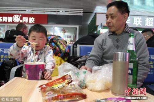 資料圖：春運(yùn)途中，有旅客喝著小酒就花生,。圖片來源：視覺中國
